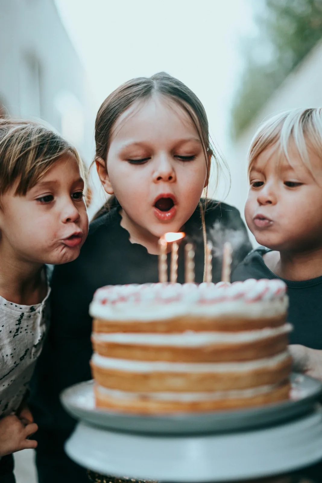Children blowing out candles on a birthday cake