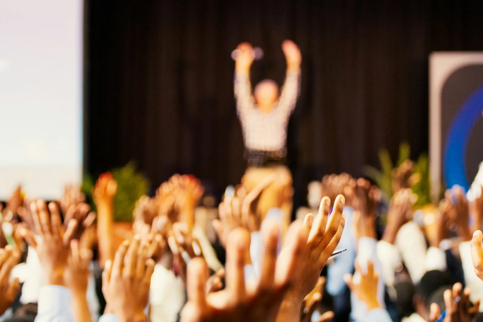 Conference attendees raising their hands together