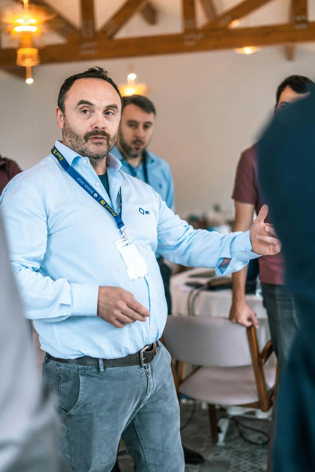 A speaker gesturing during an indoor team presentation