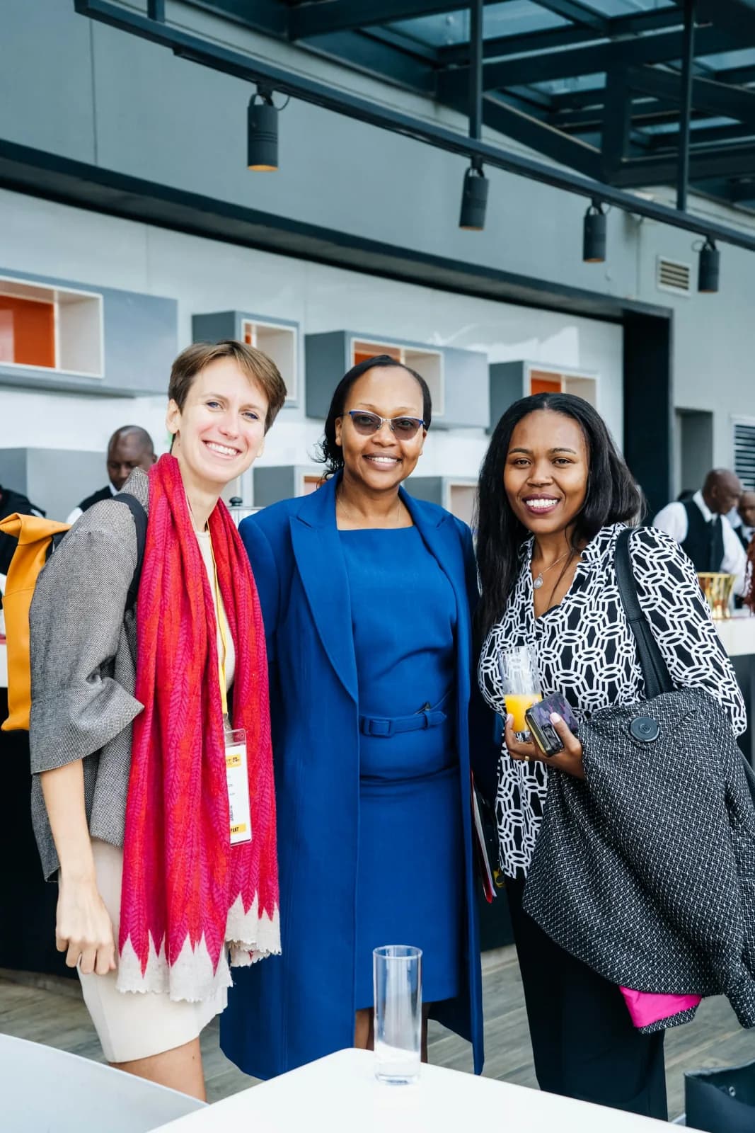 Three colleagues smiling together at a professional event