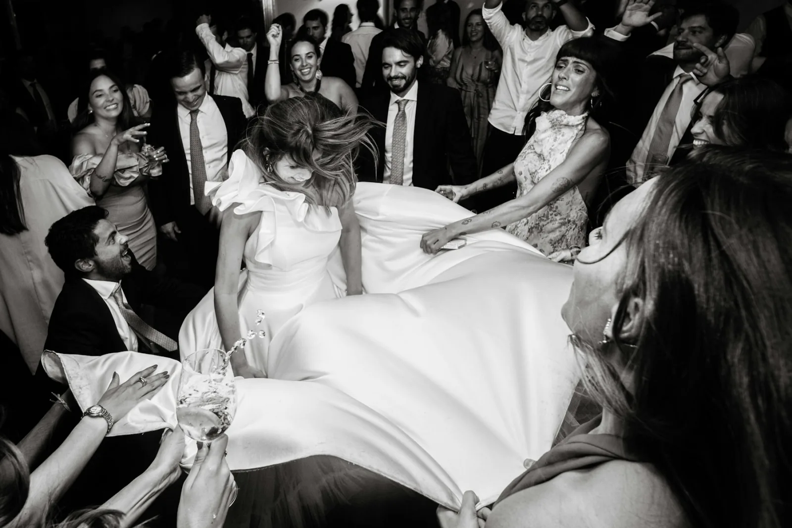 Friends lifting a bride during a wedding celebration