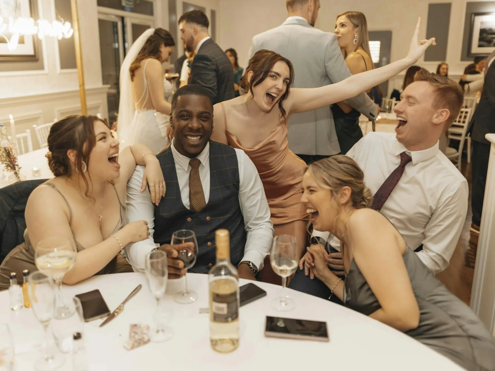 Wedding guests laughing around a dinner table